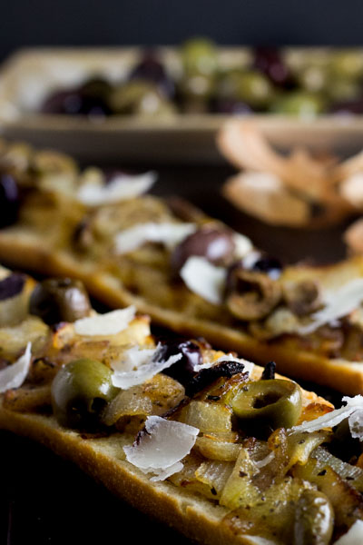 Buttery French bread is topped with caramelized onions, salty olives & ribbons of pecorino!